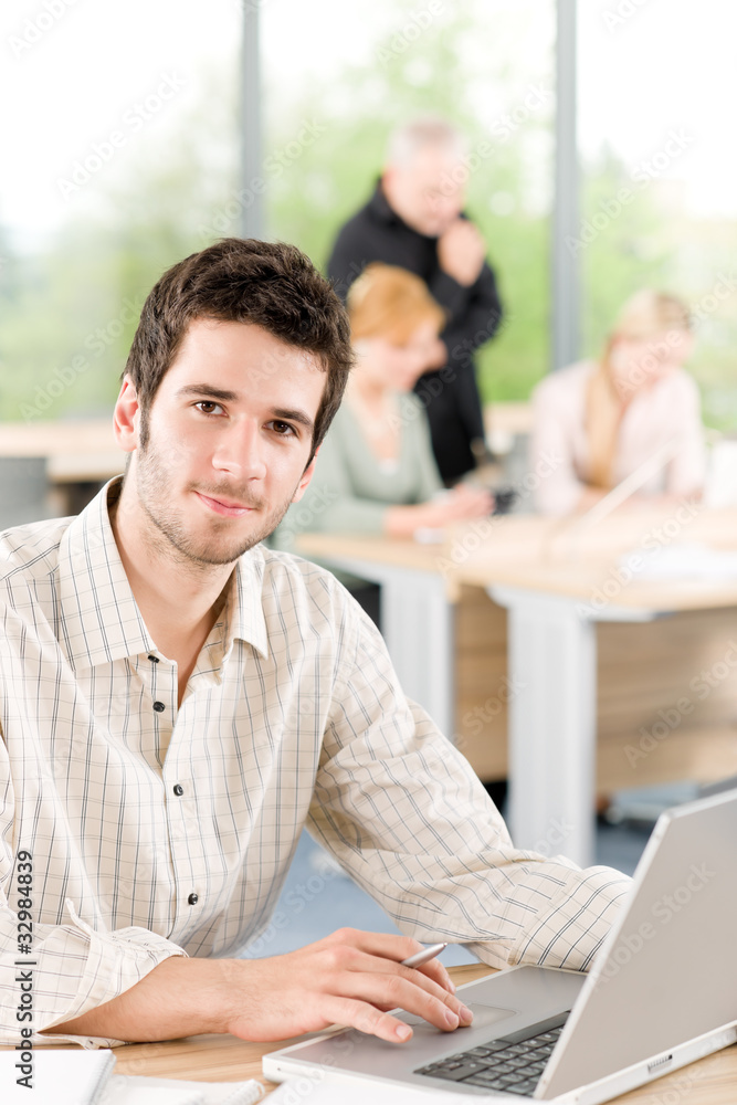Portrait of young businessman with team in back Portrait of young businessman with team in back
