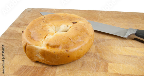 bagel and knife on chopping board isolated on white