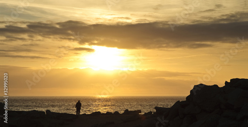 Landscape photographer silhouette against rocky cliffs and stunn photo