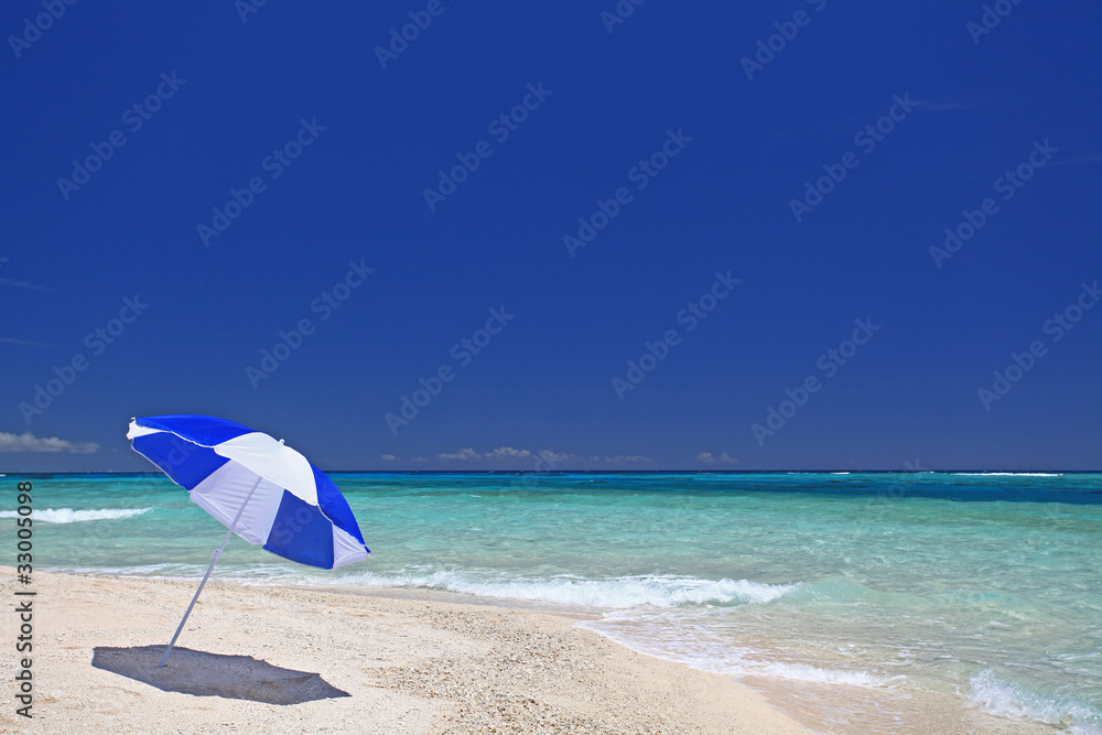 ナガンヌ島の真っ白い砂浜に立っているビーチパラソル