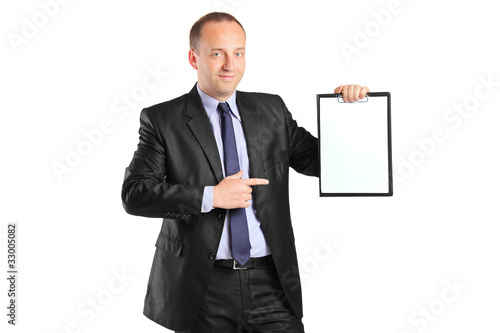 Young smiling businessperson pointing to a blank clipboard