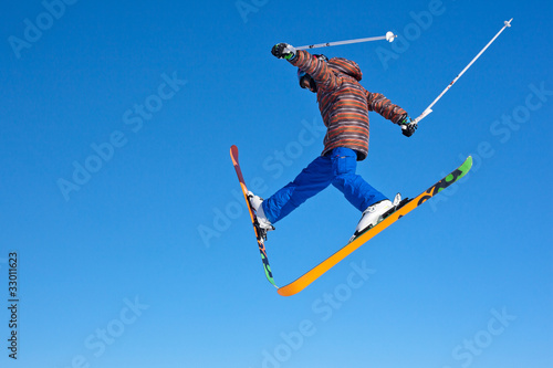 flight of young skier on blu sky background