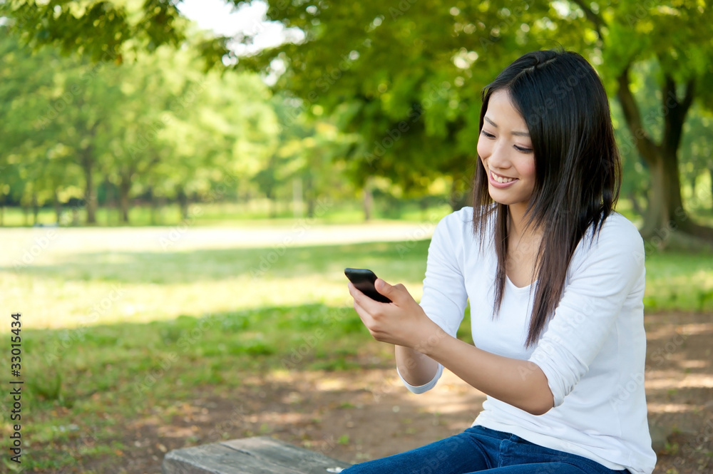 beautiful asian woman using smartphone in the park beautiful asian woman using smartphone in the park