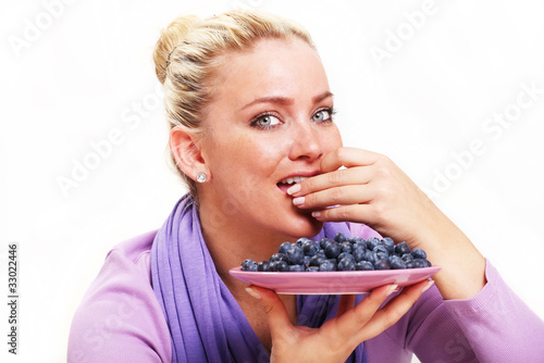 Beautiful Young Woman Eating Blueberries