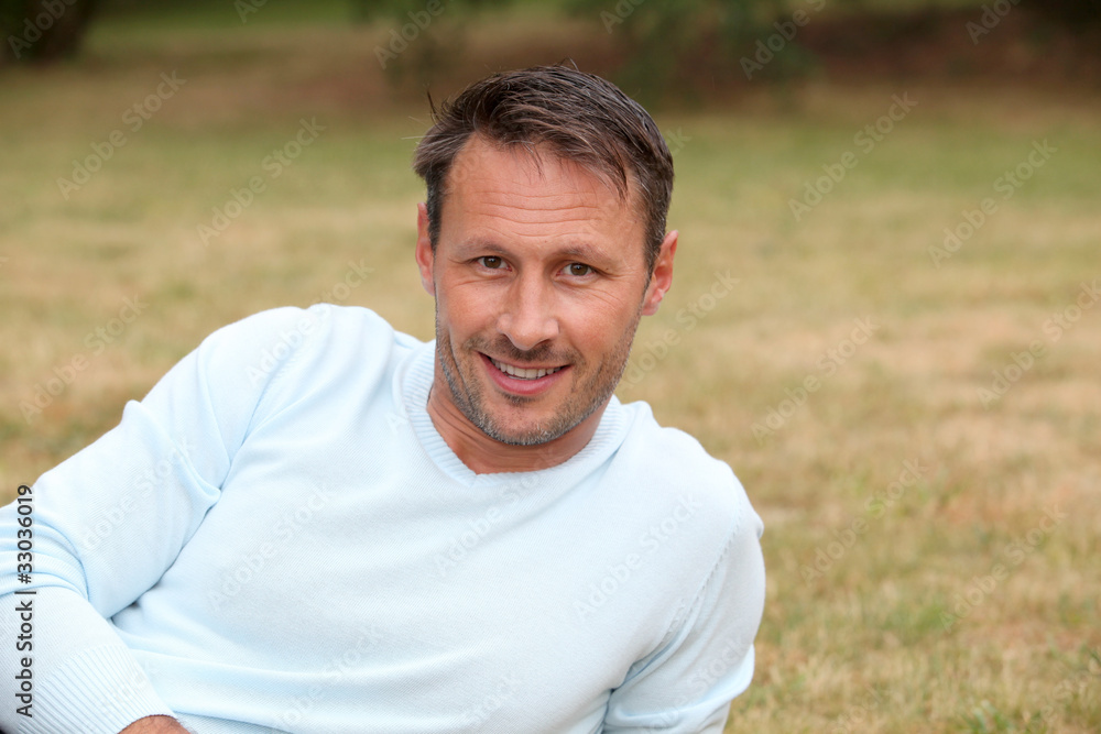 Portrait of handsome man sitting in park