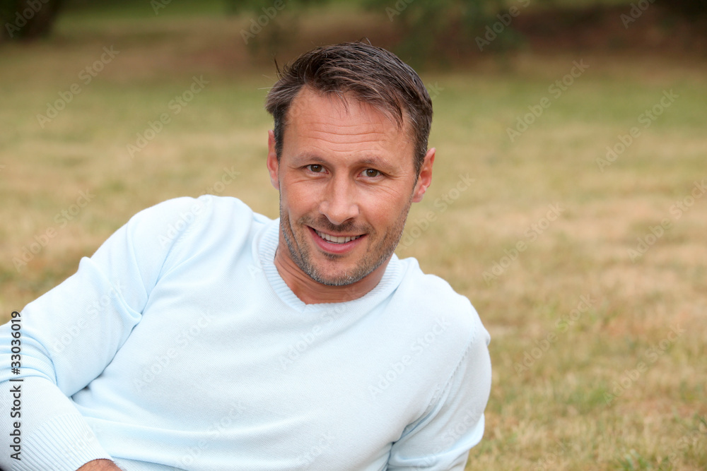 Portrait of handsome man sitting in park Portrait of handsome man sitting in park
