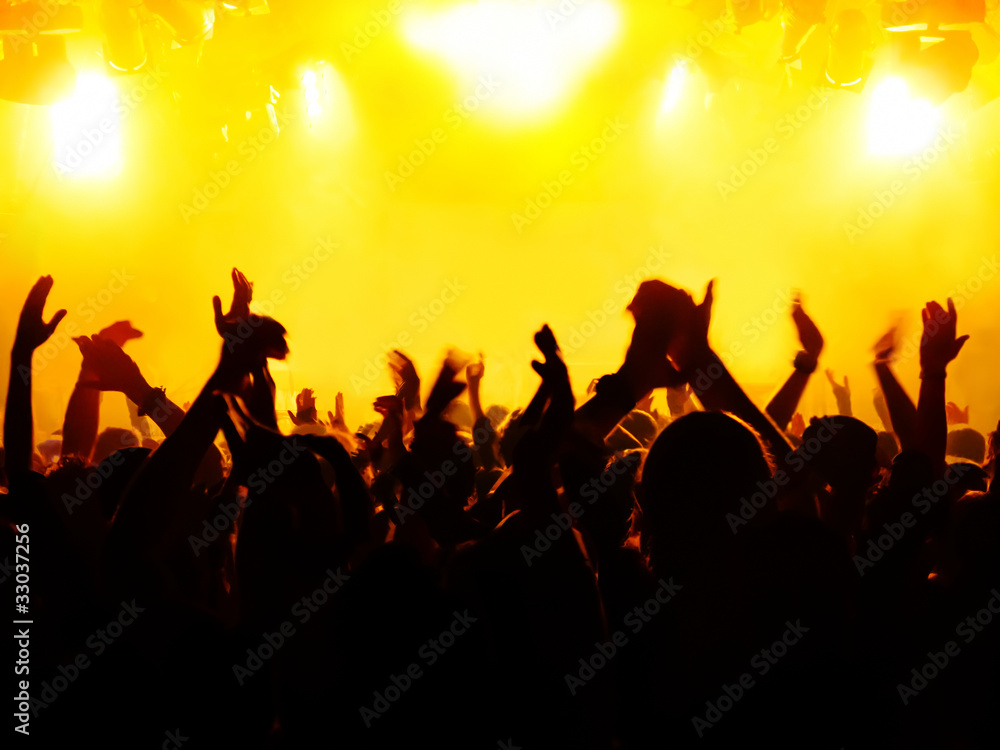 silhouettes of concert crowd in front of bright stage lights silhouettes of concert crowd in front of bright stage lights