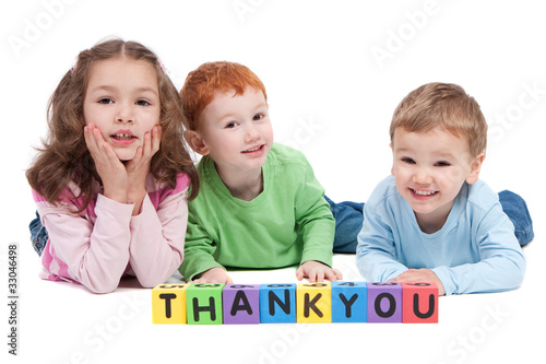 Three happy children with thankyou kids letter blocks