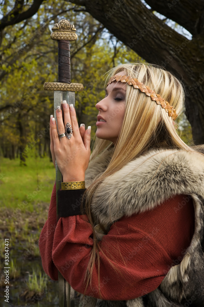 Viking girl with sword in a wood Stock Photo | Adobe Stock