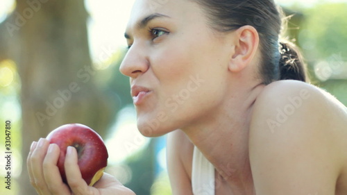 Young woman eats fresh apple outdoor