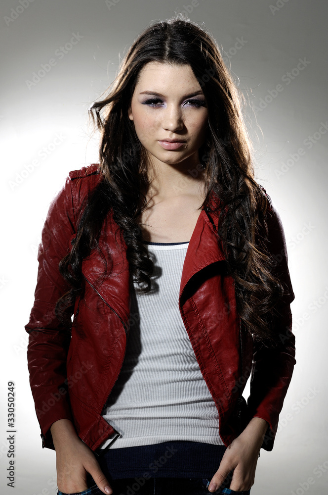 Fototapeta premium Portrait of a young beautiful woman posing in light background