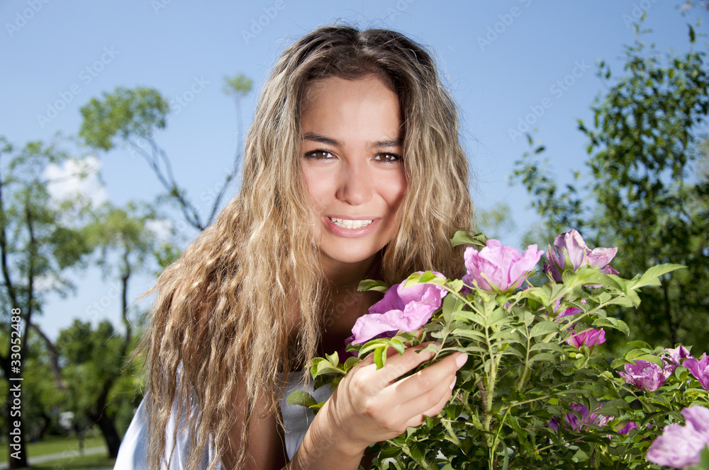 Fototapeta premium young woman standing near a dogrose