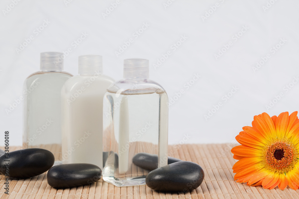 Sunflower with black stones and massage oil bottles Sunflower with black stones and massage oil bottles