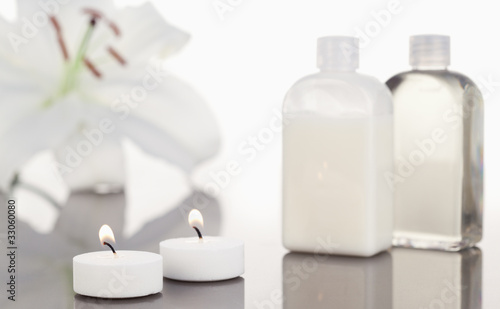 White orchid glass flasks and lighted white candles