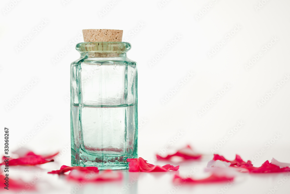 Fototapeta premium Pink petals and glass flask