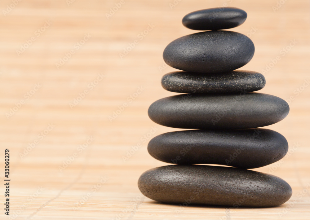Black stones stack against bamboo background Black stones stack against bamboo background