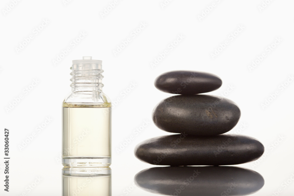 Black pebbles stack and a glass phial Black pebbles stack and a glass phial