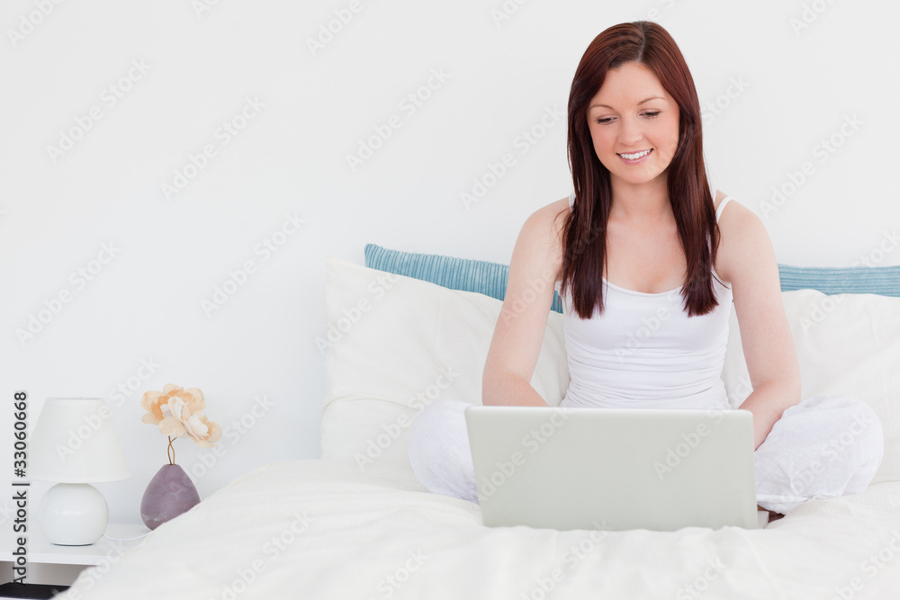 Good looking red-haired woman relaxing with her laptop while sit Good looking red-haired woman relaxing with her laptop while sit
