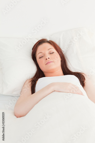 Close-up of a gorgeous red-haired female sleeping in her bed