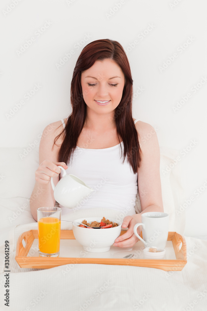 Gorgeous red-haired female drinking a glass of orange juice whil Gorgeous red-haired female drinking a glass of orange juice whil