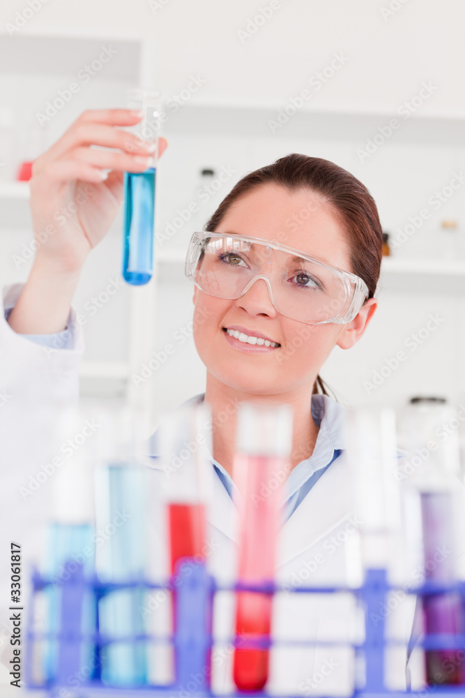 Portrait of a cute scientist looking at test tubes Portrait of a cute scientist looking at test tubes