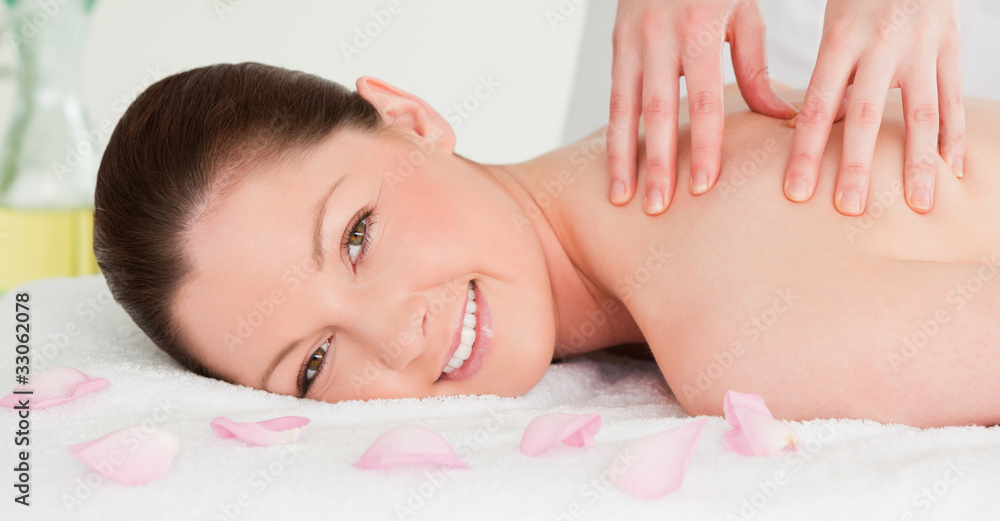 Beautiful woman having a massage while looking at the camera Beautiful woman having a massage while looking at the camera