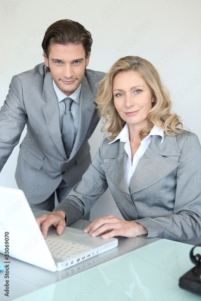 A businessman and a businesswoman working in front of a laptop A businessman and a businesswoman working in front of a laptop