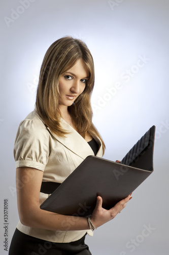 Geschaeftsfrau mit Mappe im Studio vor weissem Hintergrund
