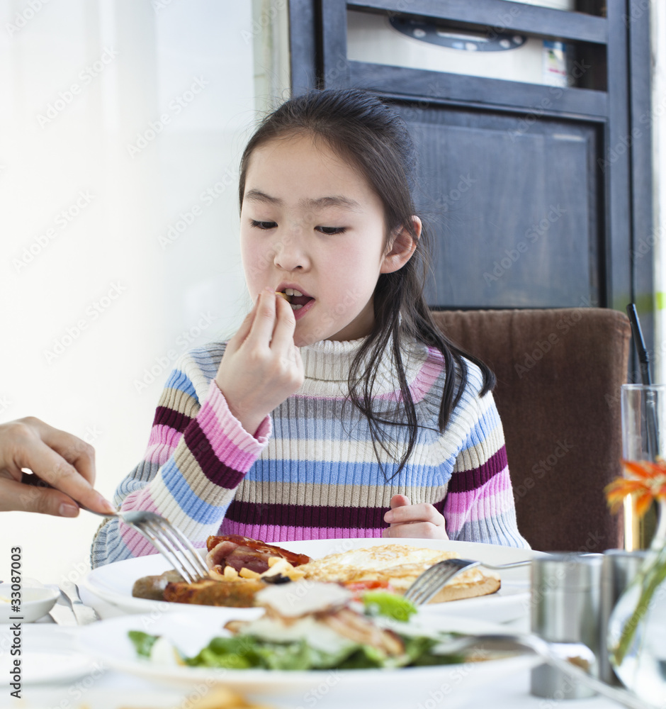 little girl eating french fries out of breakfast plate little girl eating french fries out of breakfast plate