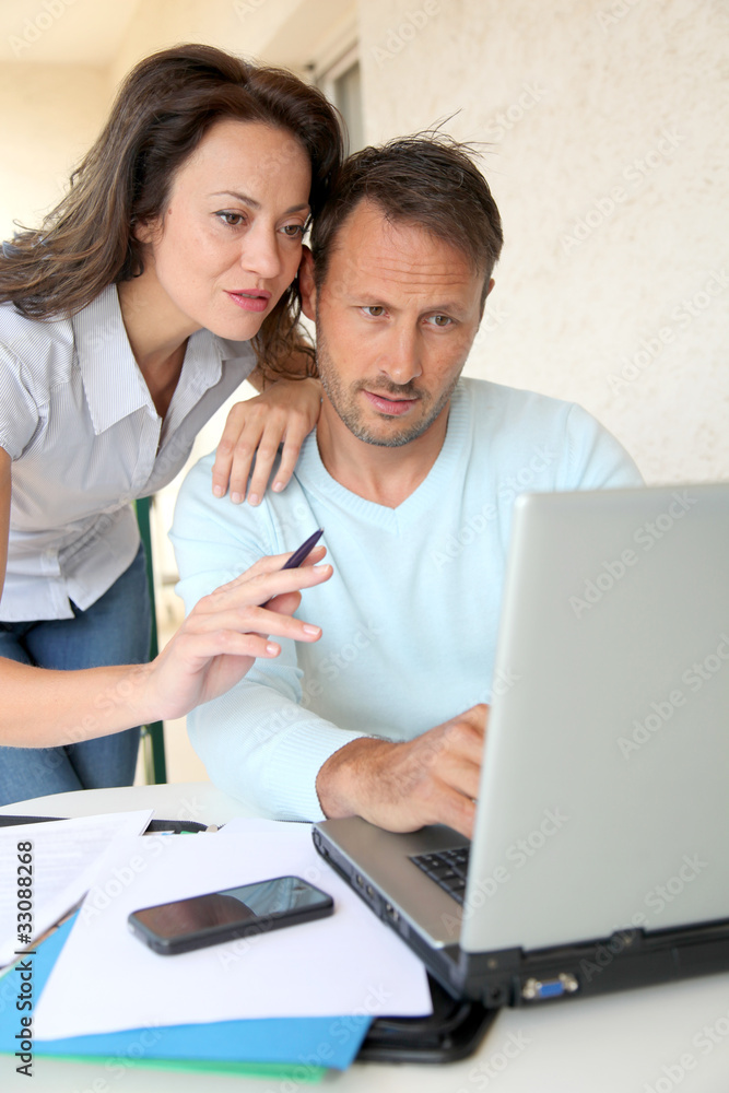 Couple working at home on laptop computer Couple working at home on laptop computer
