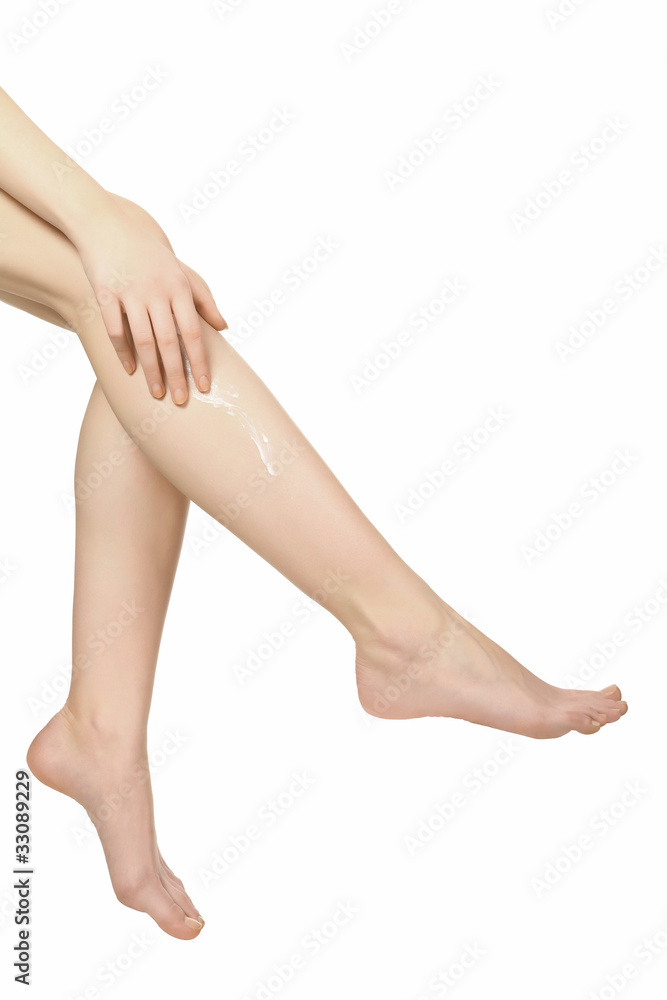 Two female legs with moisturizer body cream Two female legs with moisturizer body cream