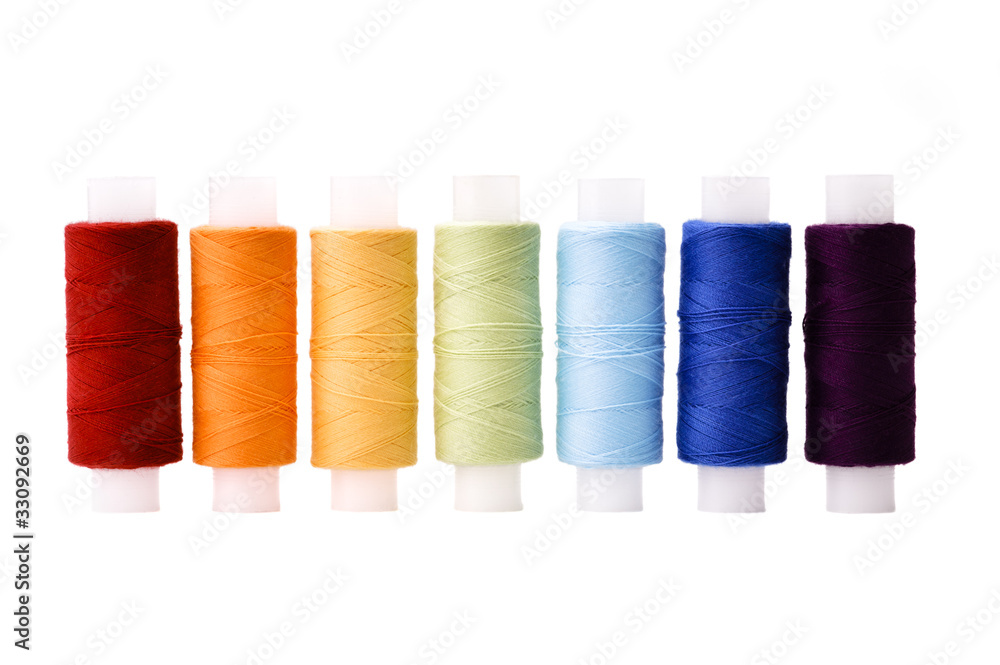 Multicoloured threads spools arranged in line as rainbow Multicoloured threads spools arranged in line as rainbow
