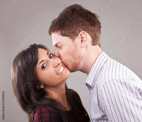 man kissing a young woman
