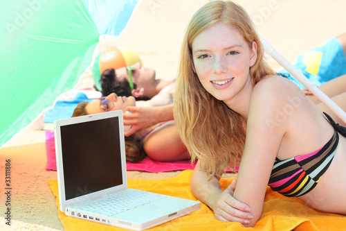 portrait of a woman on the beach with laptop
