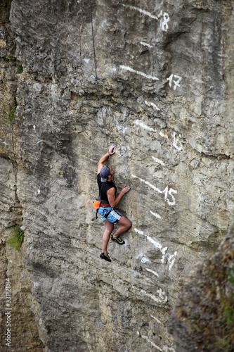 Rock climber on cliff battling his way up