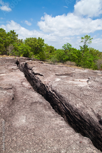Cracked Prehistory Stone on the Mountain and blue sky. © Satit _Srihin