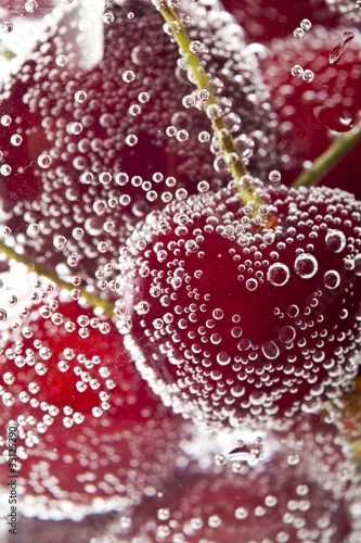 Heap of cherries in water with bubbles