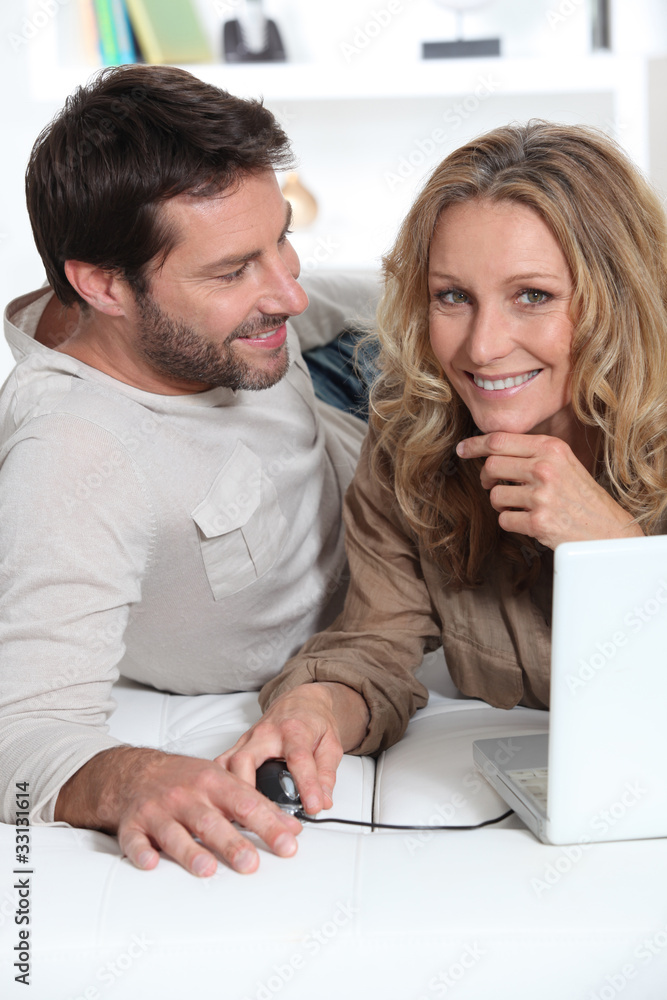 Husband looking at wife on laptop. Husband looking at wife on laptop.