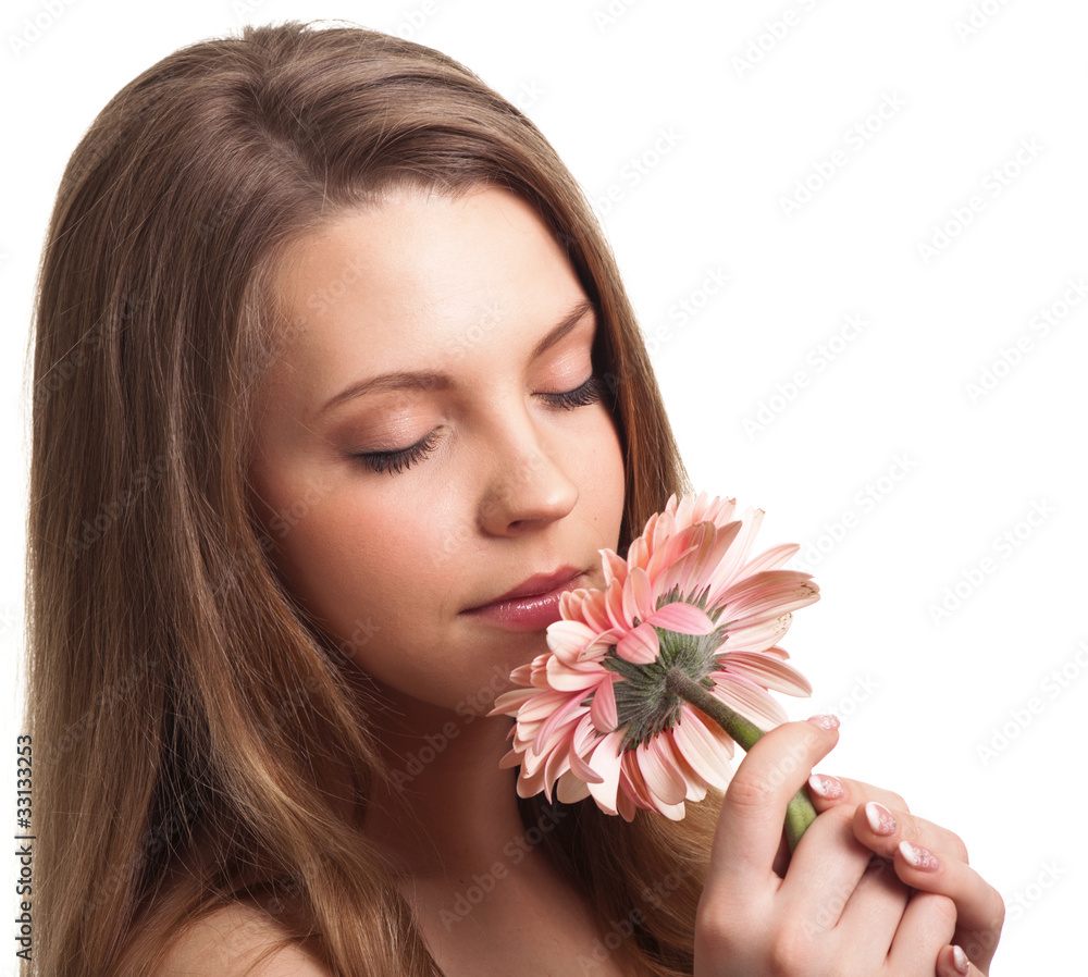 closeup of a pretty young woman smelling a pink flower