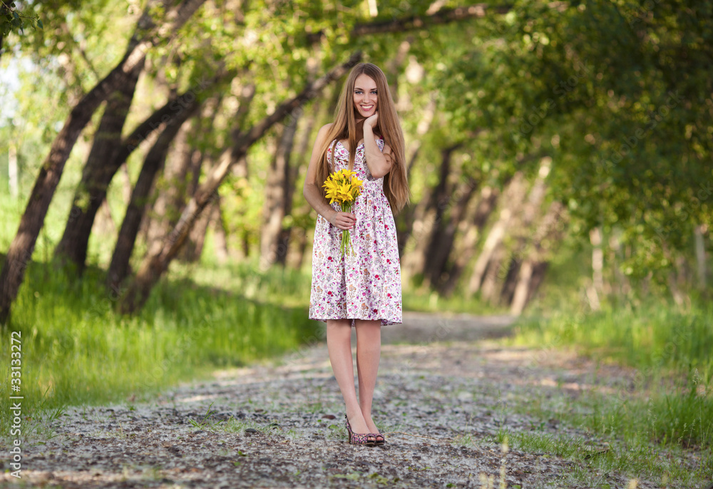 portrait of a beautiful blonde woman with yellow flowers outdoor