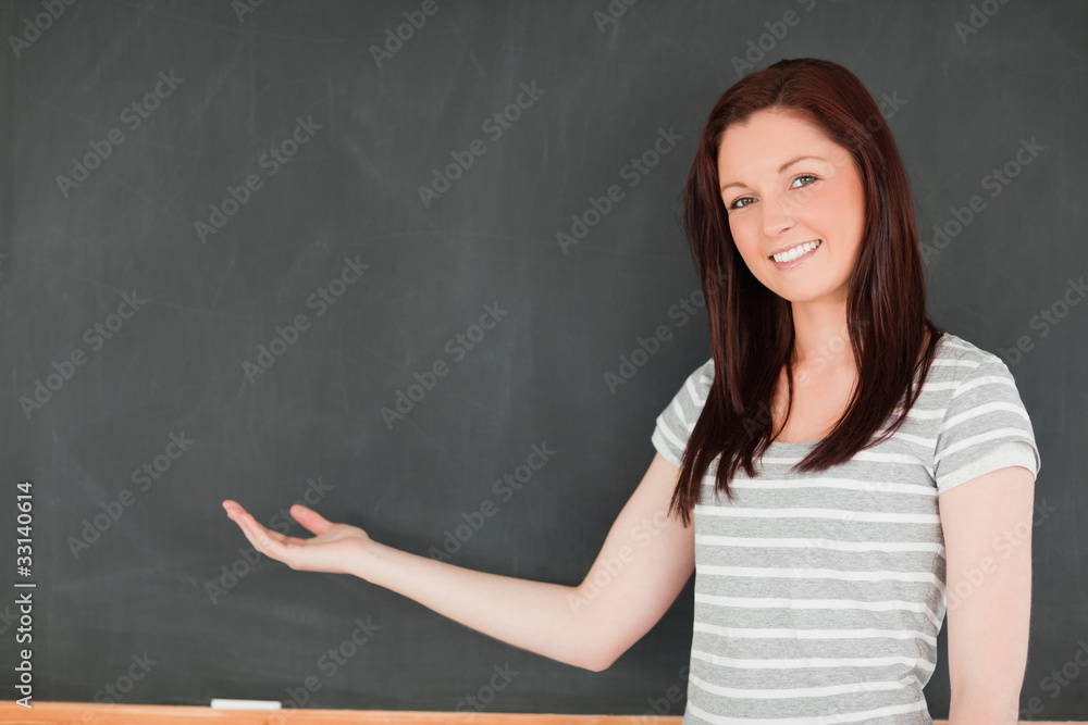 Smiling woman against blackboard with a copy space Smiling woman against blackboard with a copy space