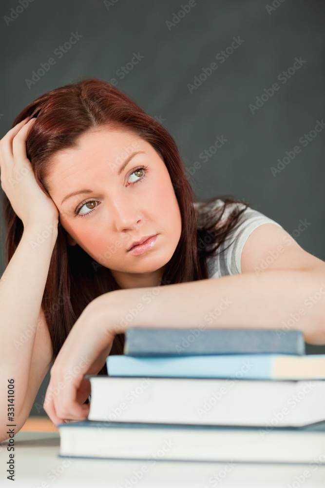 Beautiful bored student with her forearm on her books Beautiful bored student with her forearm on her books