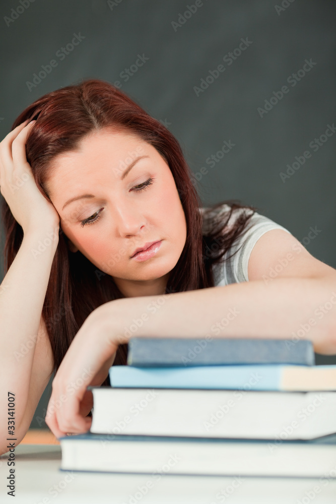 Young student fallling asleep with her forearm on her books Young student fallling asleep with her forearm on her books