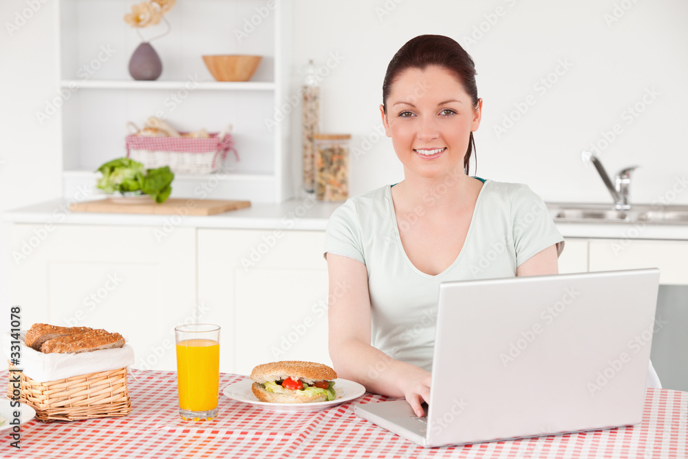Good looking woman posing while relaxing with her laptop at lunc Good looking woman posing while relaxing with her laptop at lunc