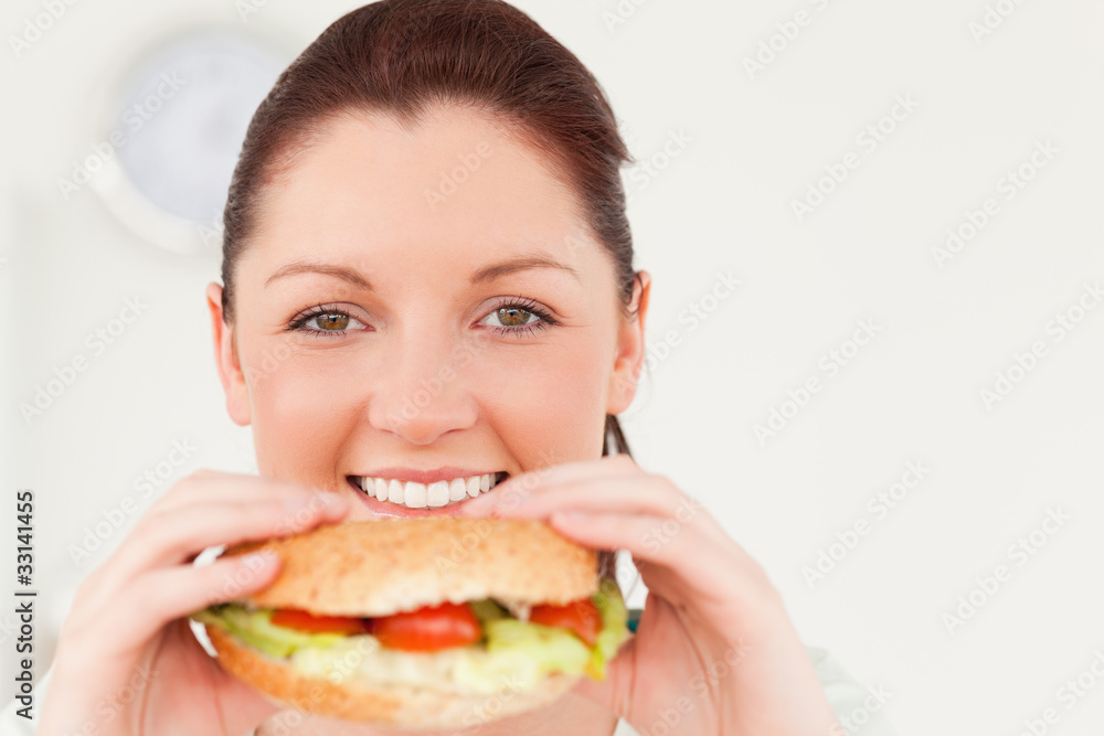 Good looking woman eating a sandwich for lunch