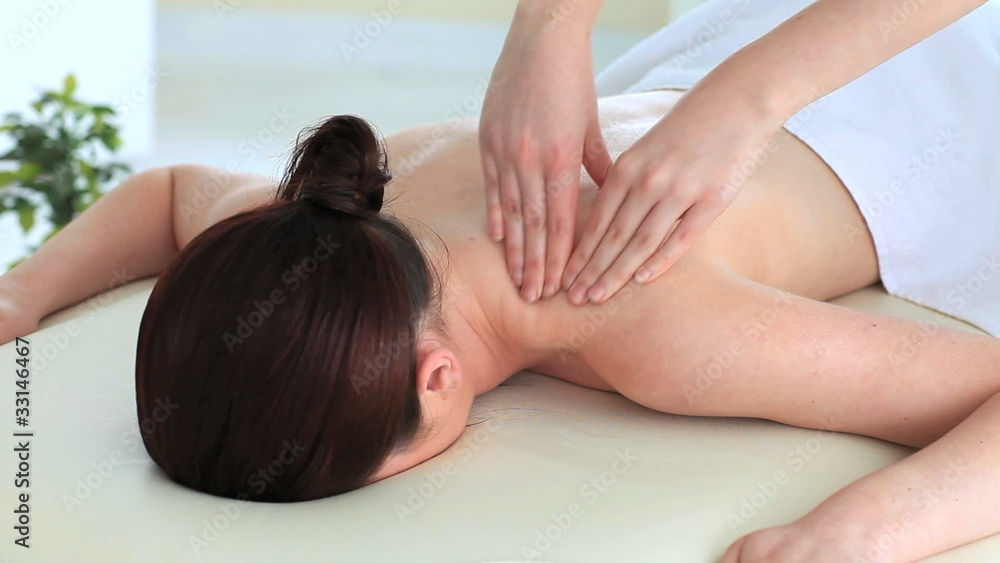 Good looking dark-haired woman receiving a massage while lying Good looking dark-haired woman receiving a massage while lying
