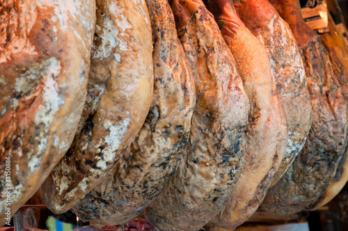 Row of ham hanging in a market place