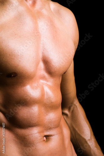 Young man with naked torso on black background