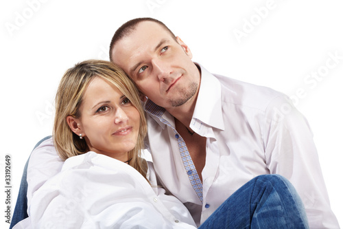 Closeup young woman and man in white shirts and blue jeans sit