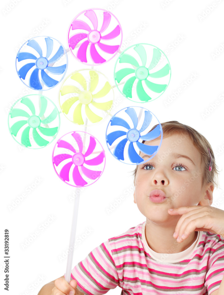 little girl blowing on big colorful toy windmill isolated